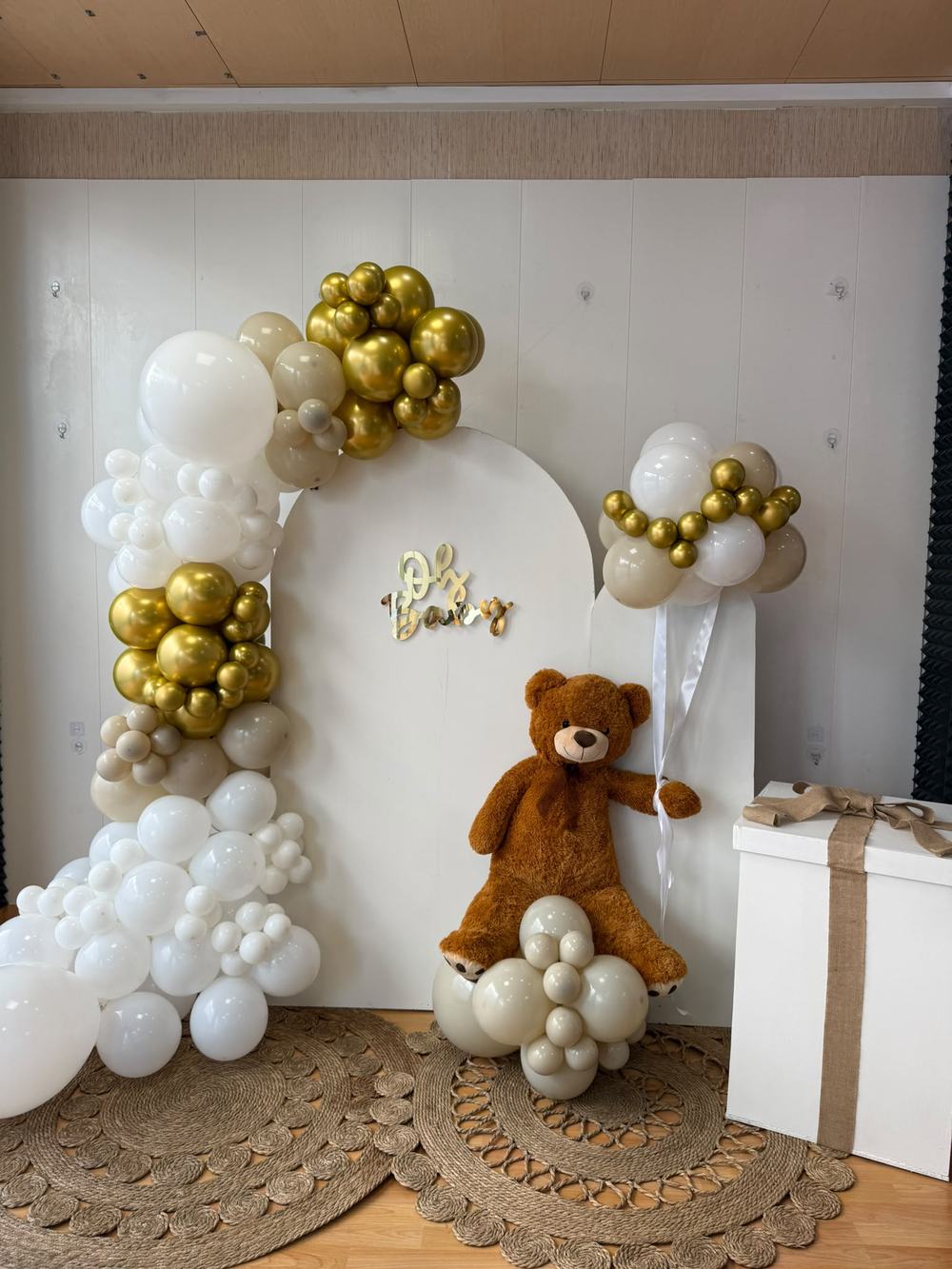Arco blanco y dorado con osito de peluche