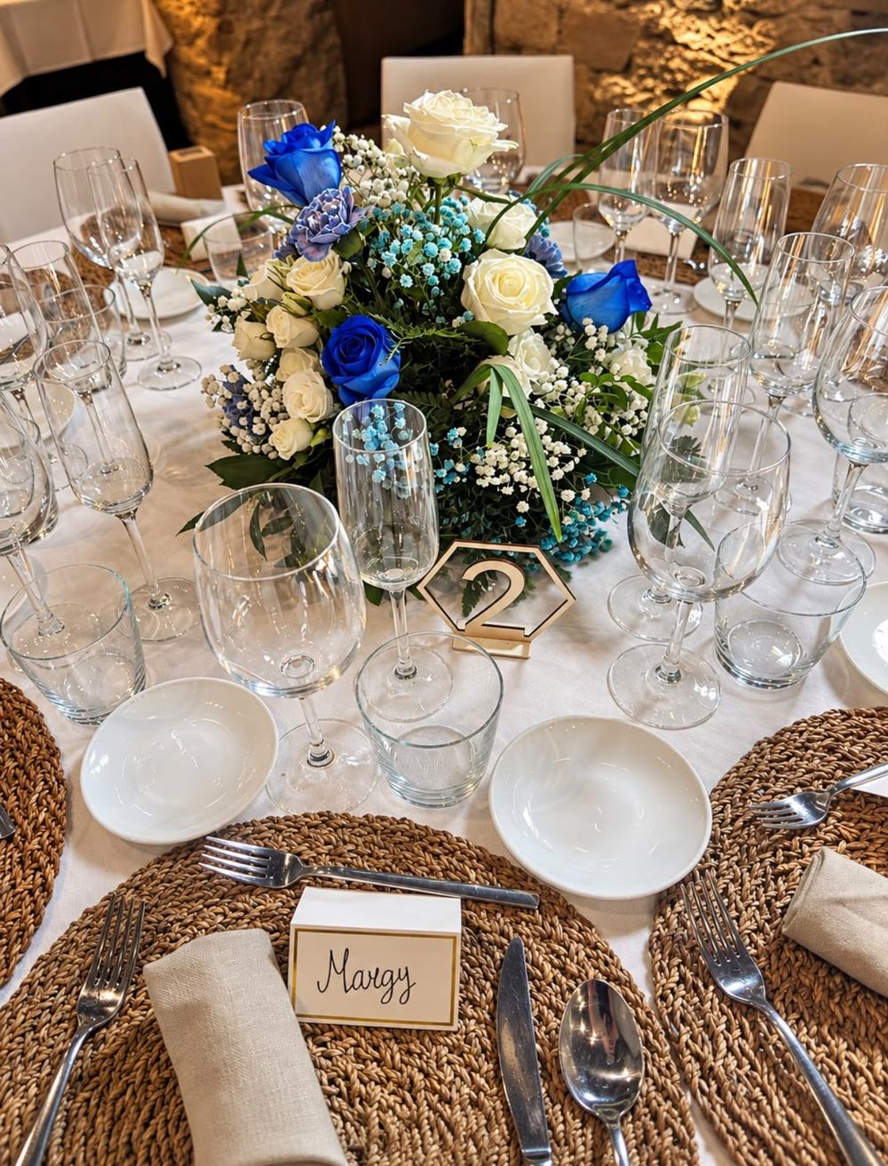 Detalle de mesa de boda con centro floral azul