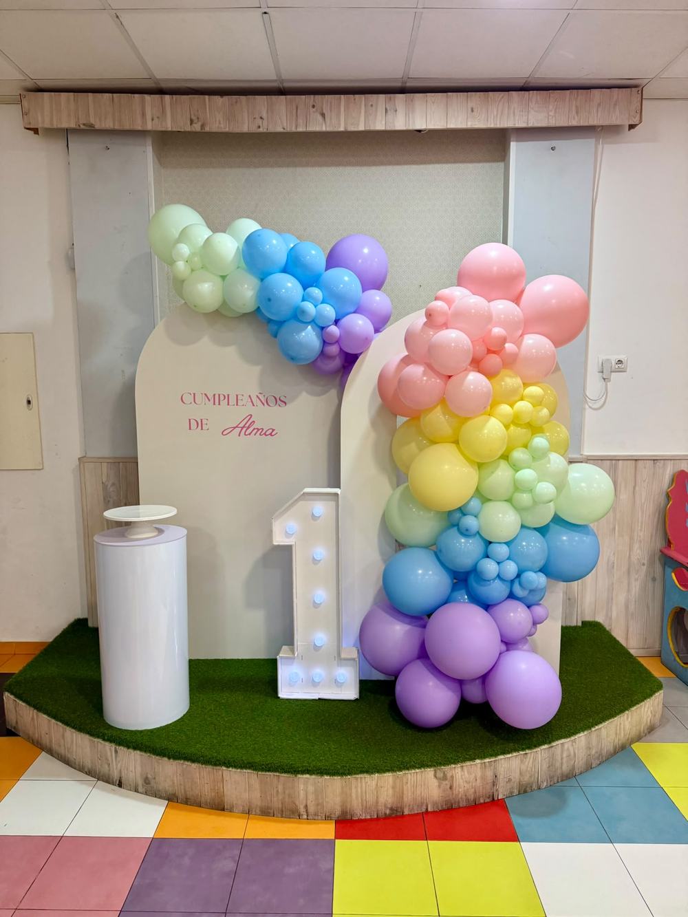 Primer cumpleaños de Alma con arco de globos pastel
