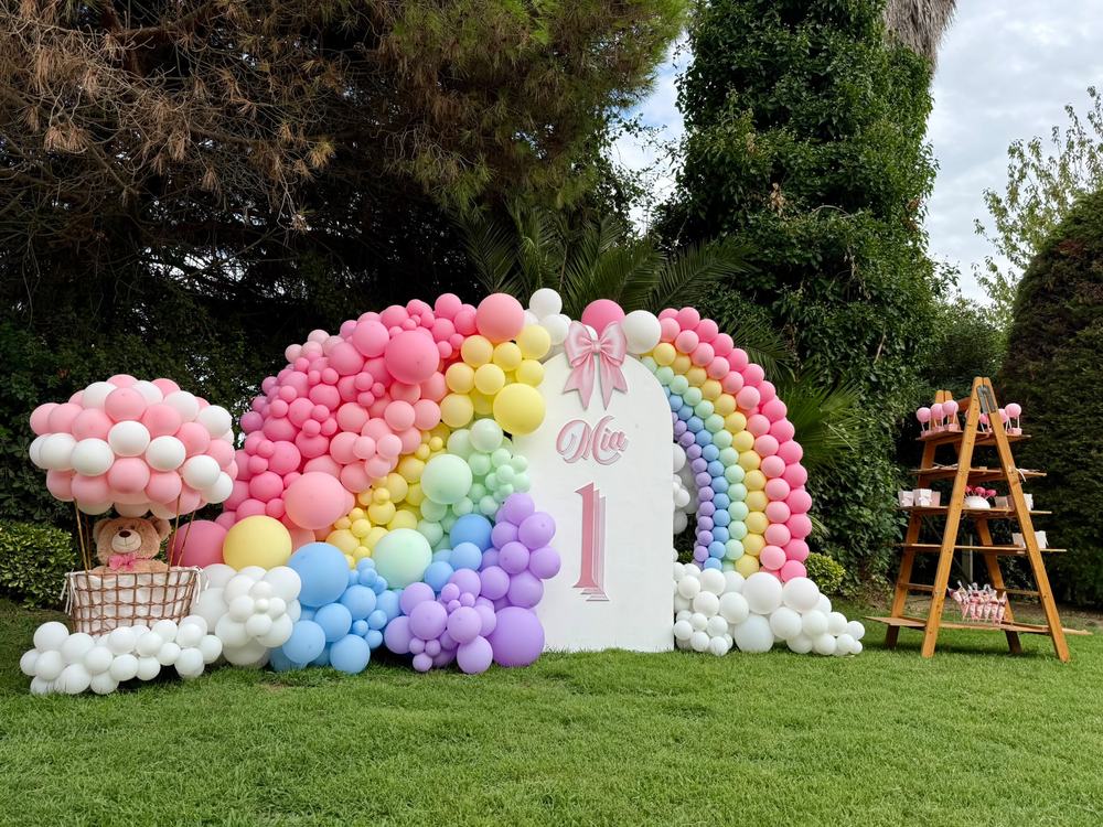 Primer cumpleaños con arco de globos arcoíris